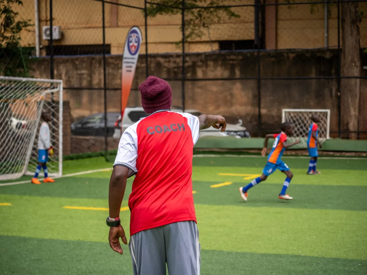 Coach directing players on the training pitch