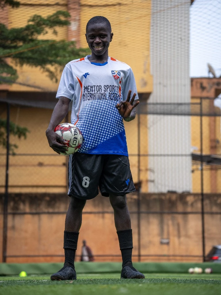 Academy player celebrating with a football on the pitch